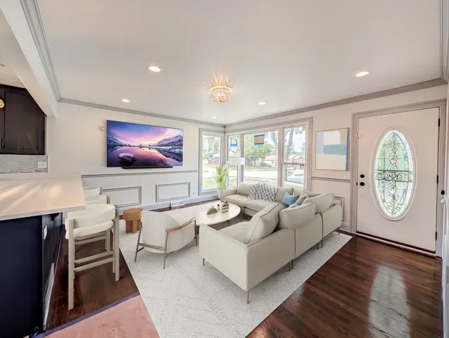 a living room with furniture a flat screen tv and a large window