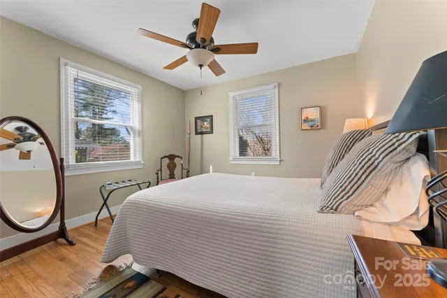 a bedroom with a bed a chandelier and a window