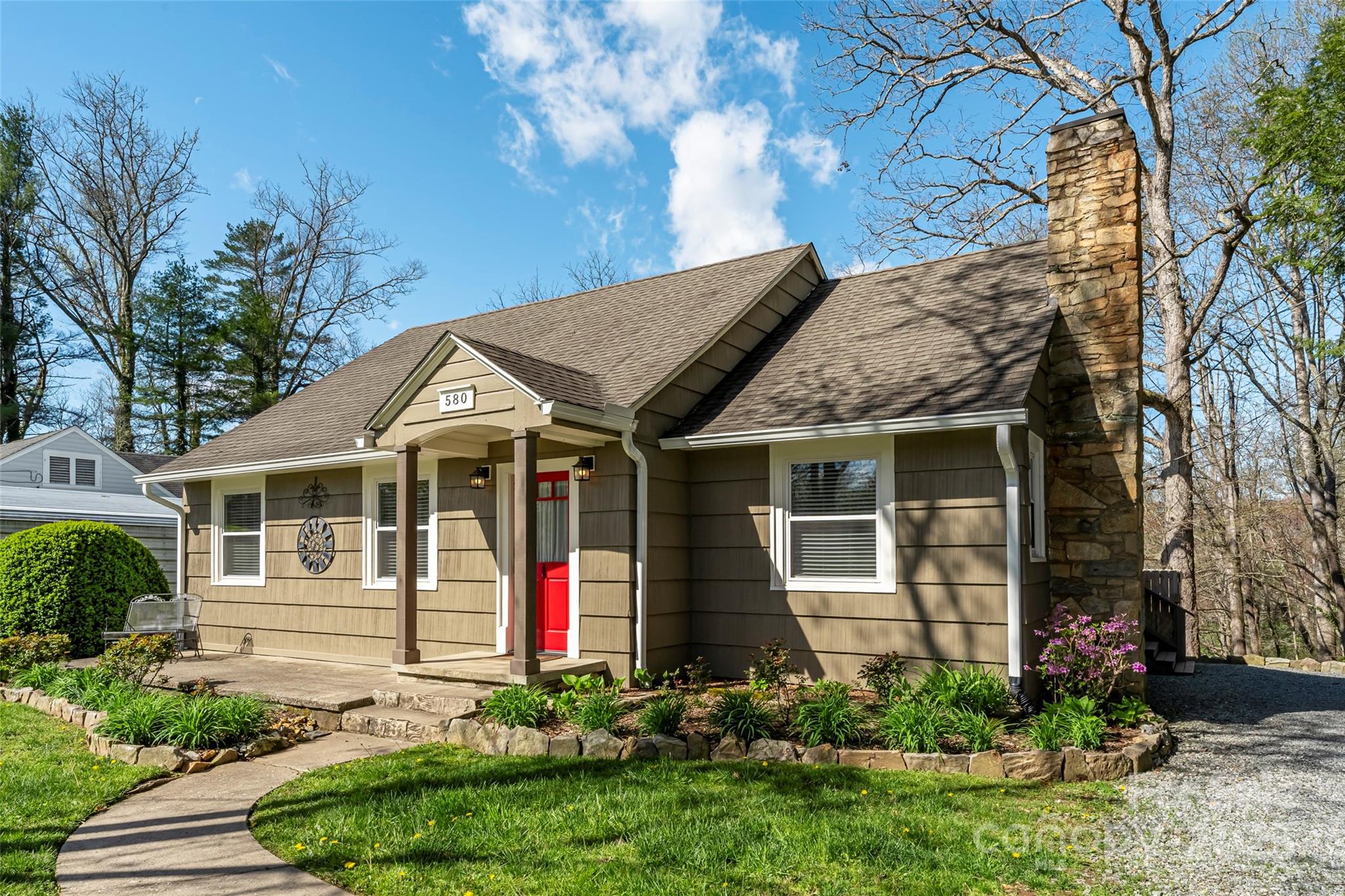 580 Maple Street Brevard, NC 28712 - Photo 2 of 28 a view of a white house with large windows and plants