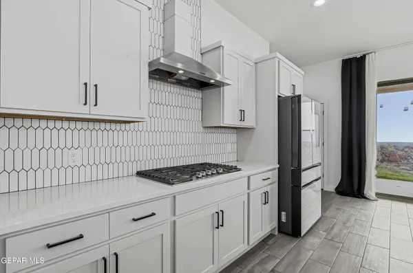 an empty room with wooden floor ceiling fan and windows
