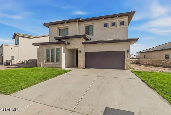 a front view of a house with a yard and garage