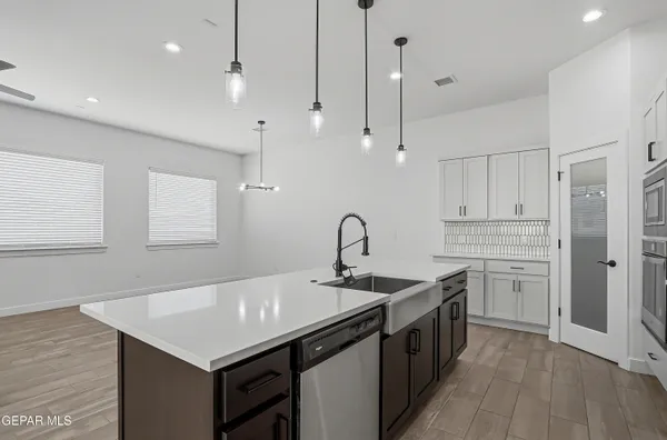 a kitchen with stainless steel appliances a sink a stove a refrigerator and island