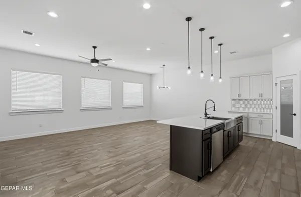 a large kitchen with stainless steel appliances kitchen island a large counter top and a wooden floors