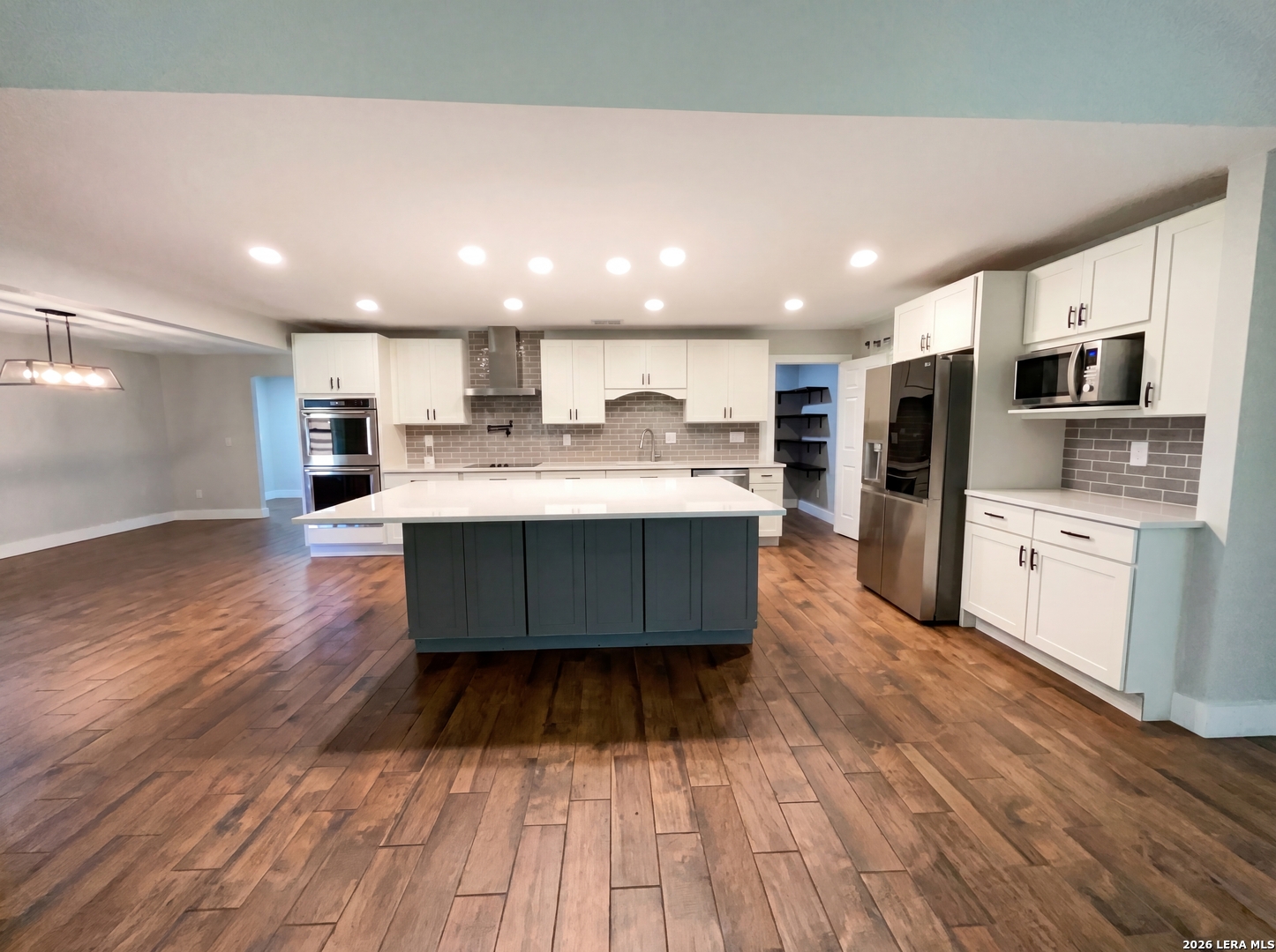 15422 Geronimo Loop San Antonio, TX 78254 - Photo 2 of 21 a living room with stainless steel appliances kitchen island granite countertop wooden floors wooden cabinets and sink