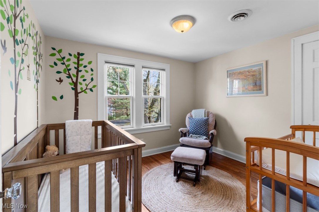 3124 Warrington Road Cleveland, OH 44120 - Photo 24 of 36 Bedroom featuring a crib, baseboards, wood finished floors, and visible vents