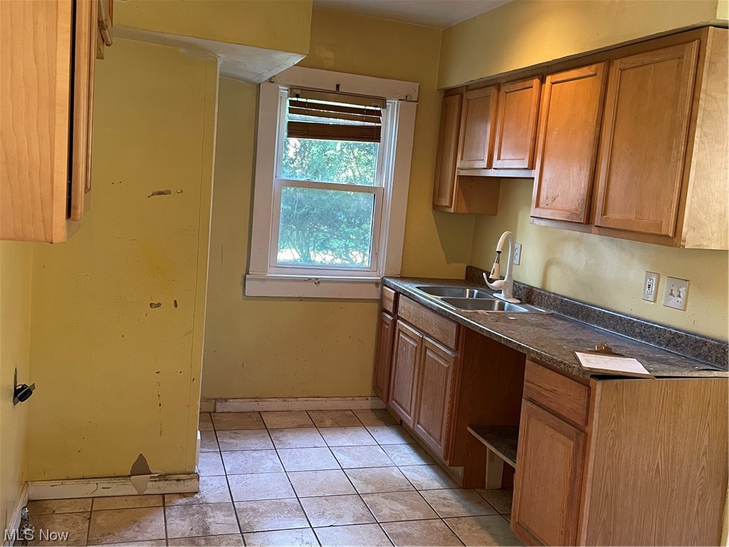 1730 Wood Road Cleveland Heights, OH 44121 - Photo 11 of 34 Kitchen with dark countertops, brown cabinets, and light tile floors