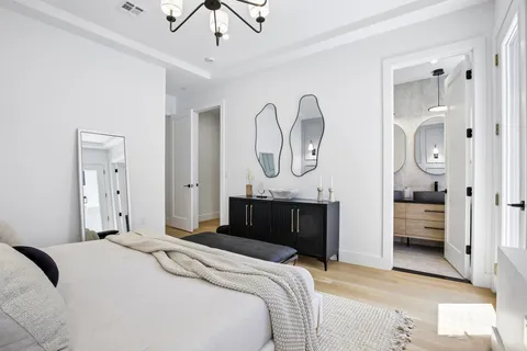 a bedroom with bed and a chandelier