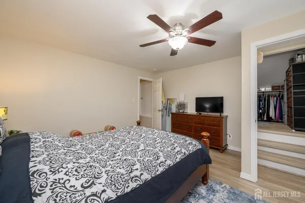 a bed room with a bed a television and dresser