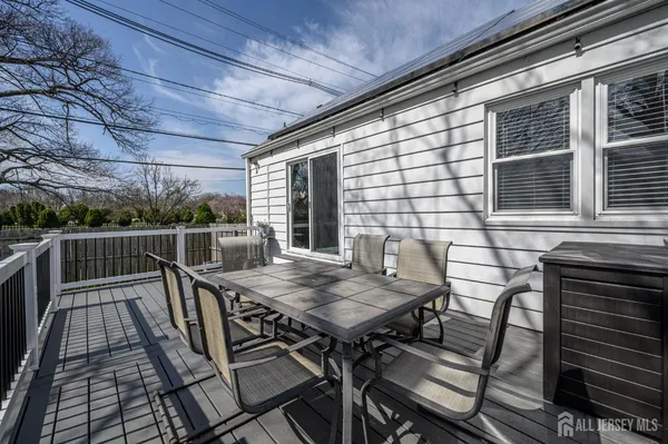 a view of a roof deck with table and chairs with wooden floor and fence