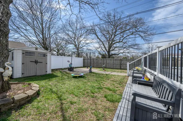 a view of a backyard with couches plants and large trees