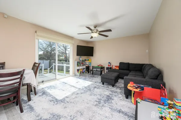 a living room with furniture a flat screen tv and a floor to ceiling window