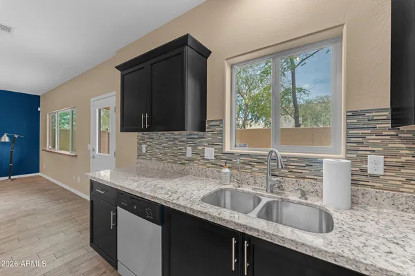 a kitchen with granite countertop a sink and a stove