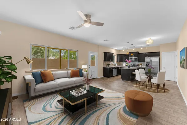 a living room with furniture kitchen view and a large window