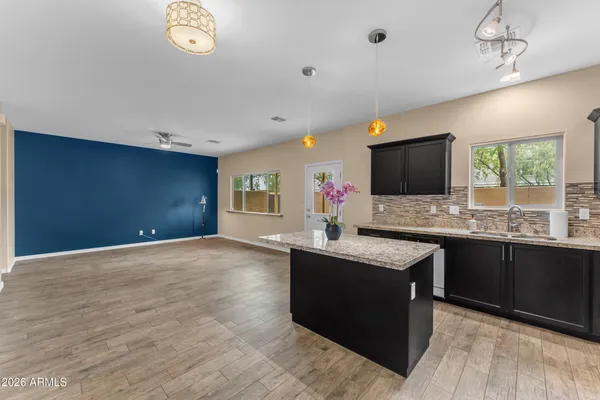 a living room with granite countertop furniture a flat screen tv and kitchen view