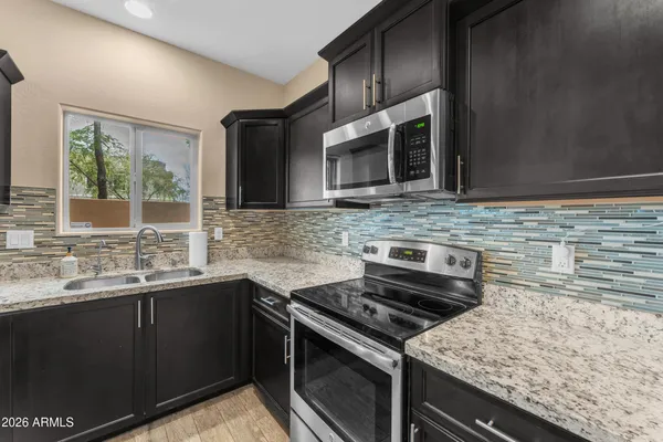 a kitchen with stainless steel appliances a sink stove and microwave