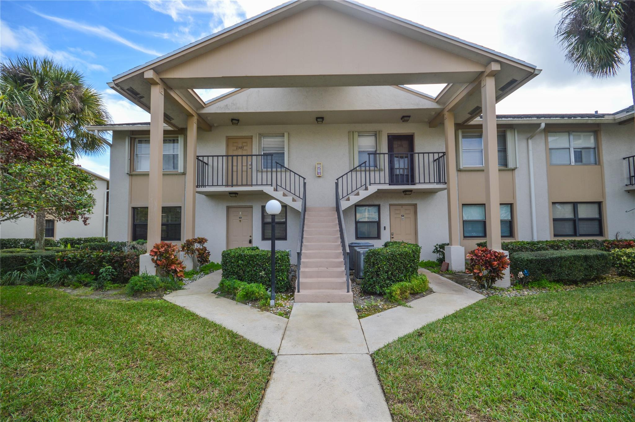 3151 Southeast Aster Lane, Unit 1301 Stuart, FL 34994 - Photo 1 of 30 a front view of house with yard and green space