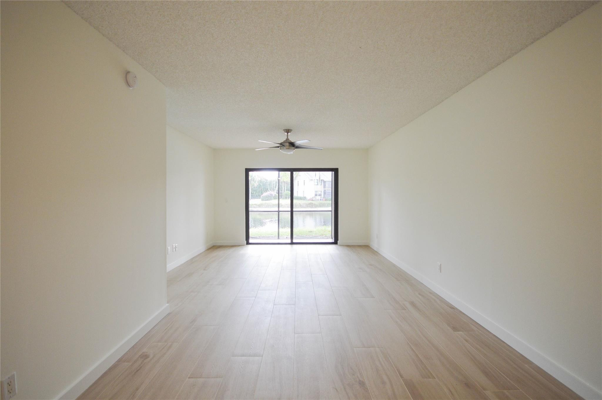 3151 Southeast Aster Lane, Unit 1301 Stuart, FL 34994 - Photo 13 of 30 an empty room with wooden floor and windows