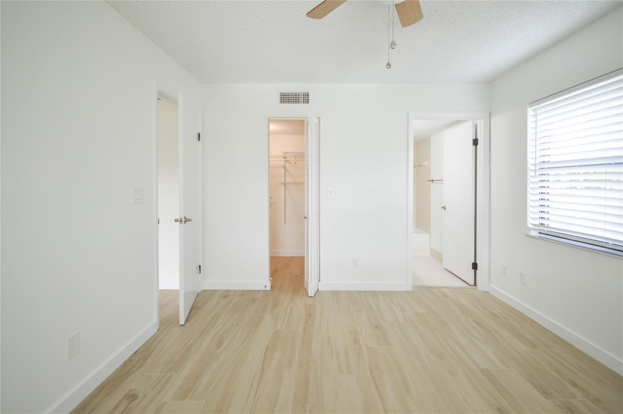 3151 Southeast Aster Lane, Unit 1301 Stuart, FL 34994 - Photo 15 of 30 an empty room with wooden floor and windows