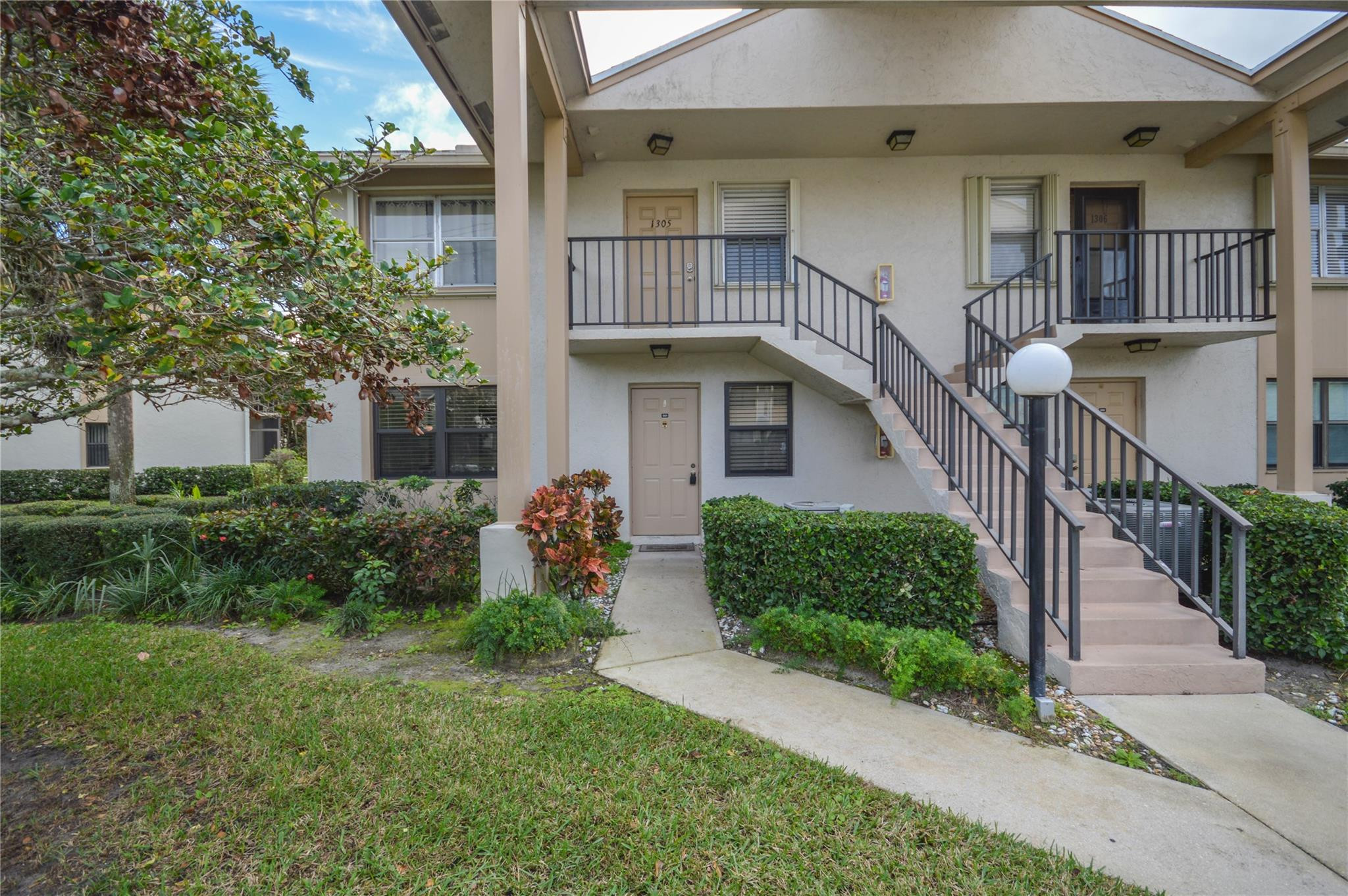 3151 Southeast Aster Lane, Unit 1301 Stuart, FL 34994 - Photo 2 of 30 front view of a house with a yard