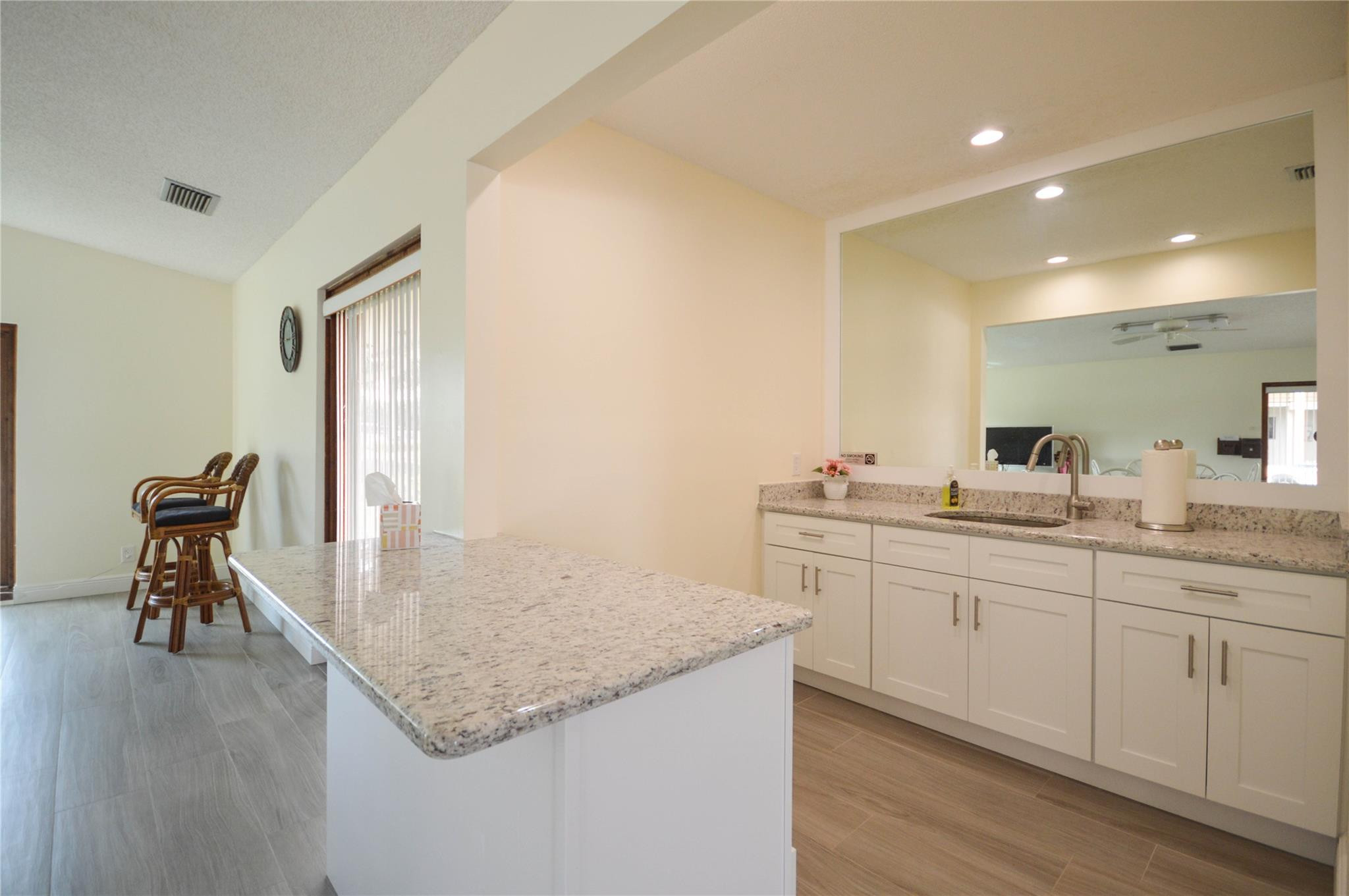 3151 Southeast Aster Lane, Unit 1301 Stuart, FL 34994 - Photo 25 of 30 a bathroom with a granite countertop sink and a mirror