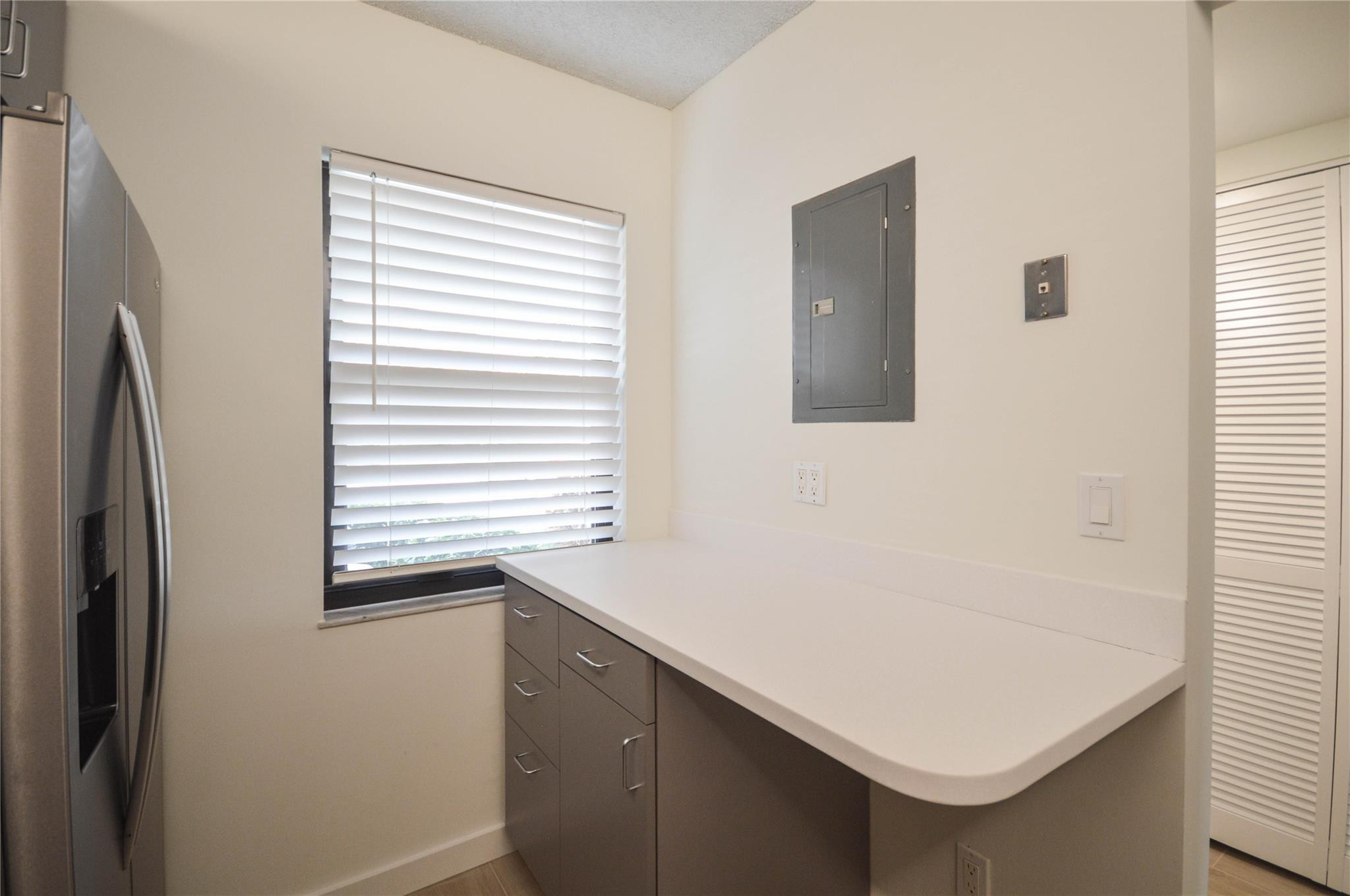 3151 Southeast Aster Lane, Unit 1301 Stuart, FL 34994 - Photo 6 of 30 a kitchen with a white cabinets and a refrigerator