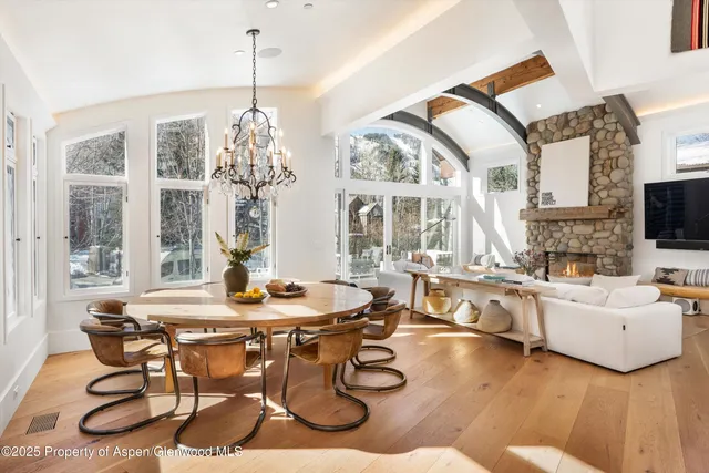 a dining room with furniture a chandelier and wooden floor