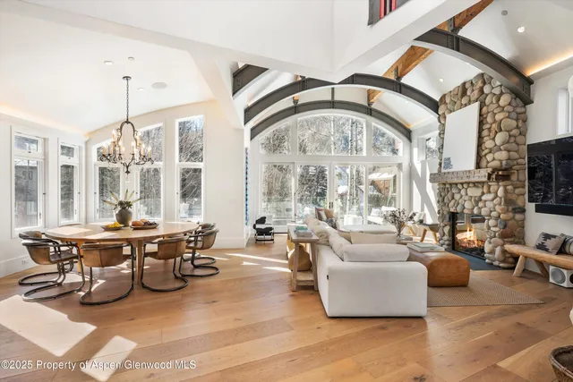 a living room with fireplace furniture and a large window