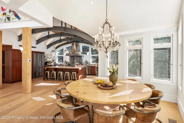 a dining room with furniture a chandelier and wooden floor