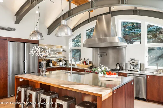 a kitchen with stainless steel appliances granite countertop a sink a counter space and a view of dining table