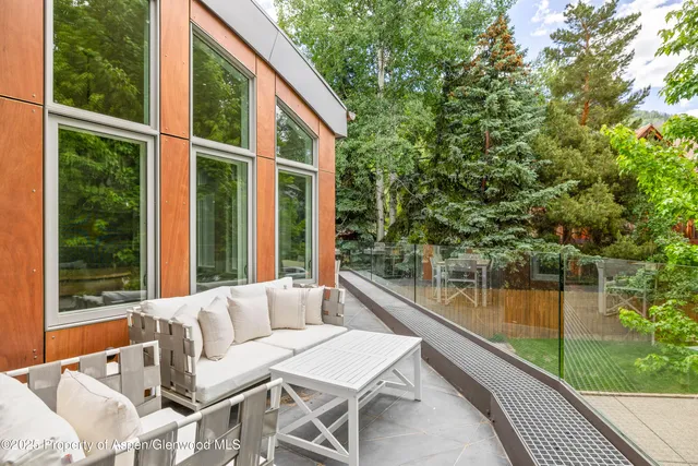 a patio with table and chairs and potted plants