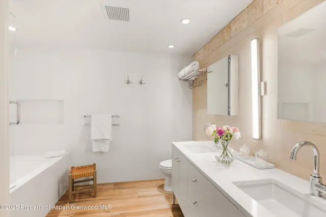 a spacious bedroom with a bed a fireplace and a flat screen tv