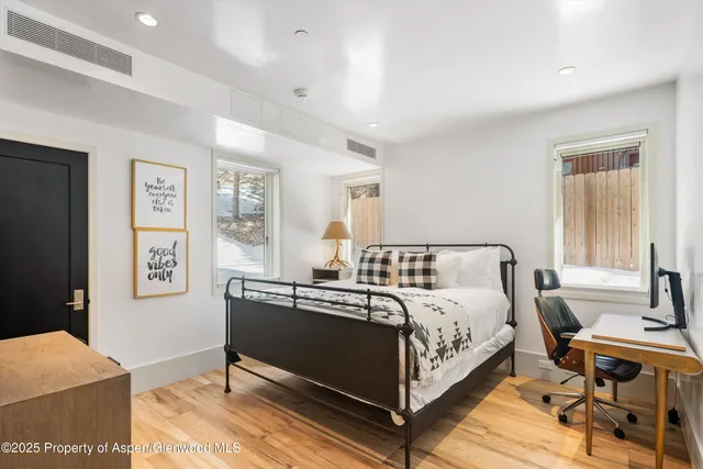 a bedroom with a bed and wooden floor