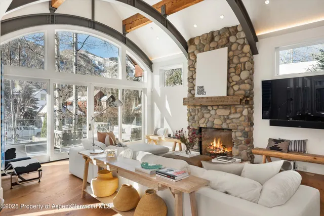 a living room with furniture a flat screen tv and a fireplace