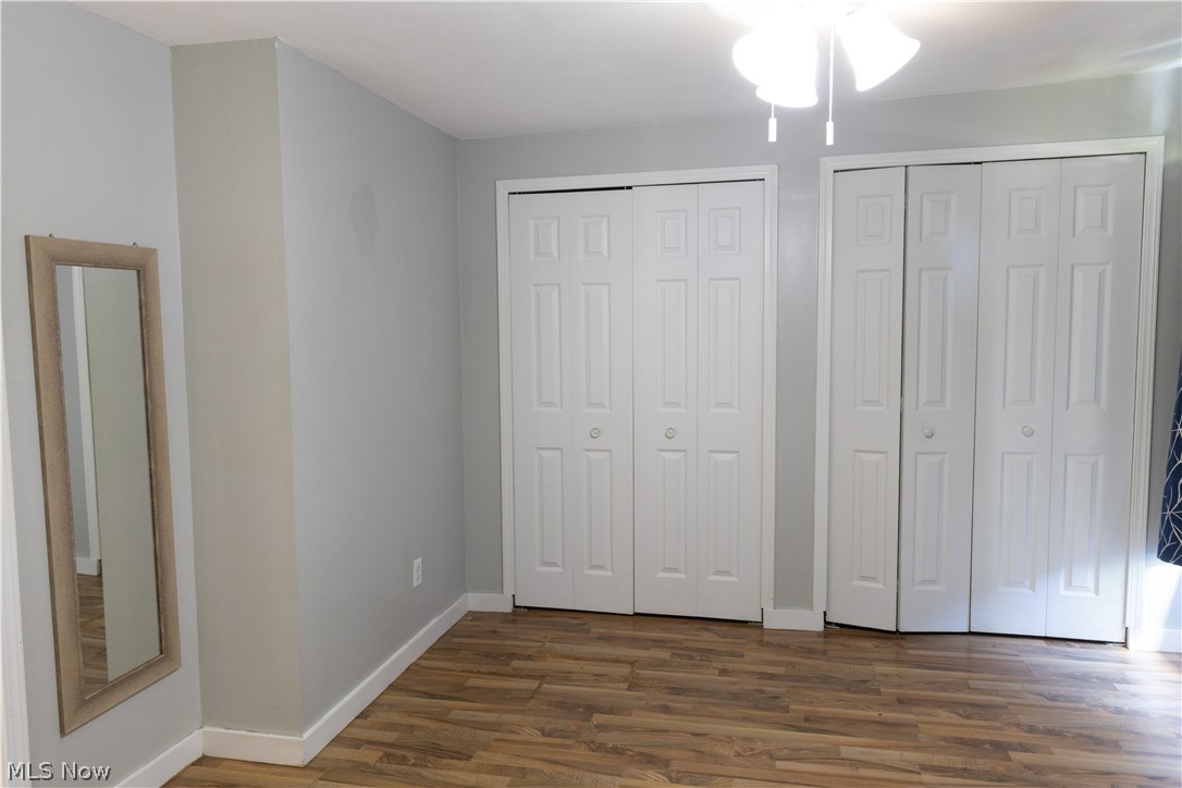 180 South Ridge Road West Geneva, OH 44041 - Photo 18 of 40 Unfurnished bedroom featuring multiple closets and dark wood-type flooring