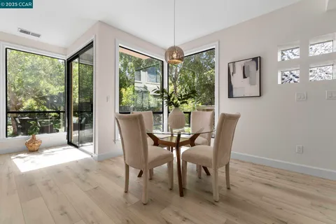 a dining room with furniture a chandelier and wooden floor