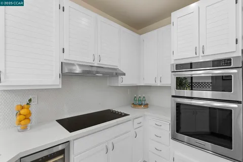 a kitchen with stainless steel appliances white cabinets and a stove a sink