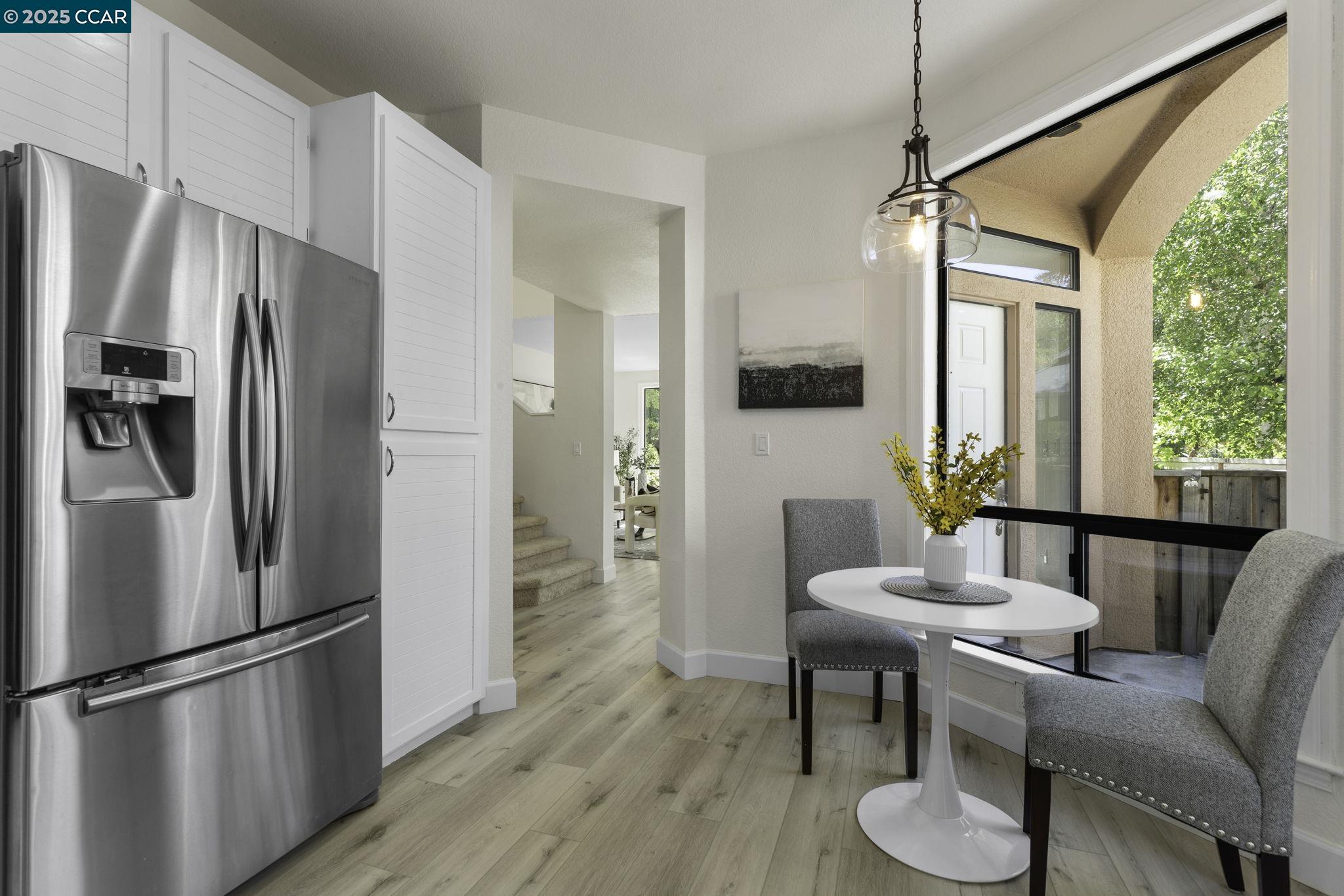 731 Lakemont Place, Unit 7 San Ramon, CA 94582 - Photo 22 of 55 a kitchen with stainless steel appliances a refrigerator a microwave a dining table and chairs with wooden floor