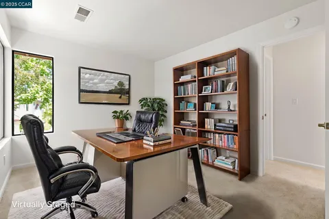 a room with white cabinets and clock on the wall