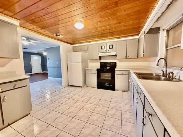 a kitchen with stainless steel appliances granite countertop a sink and a refrigerator