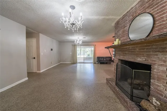 a living room with stainless steel appliances kitchen island granite countertop furniture and a chandelier