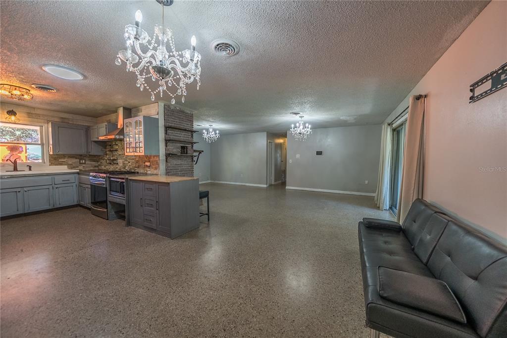 1740 Southeast 164th Circle Ocklawaha, FL 32179 - Photo 5 of 48 a living room with stainless steel appliances kitchen island granite countertop furniture and a chandelier