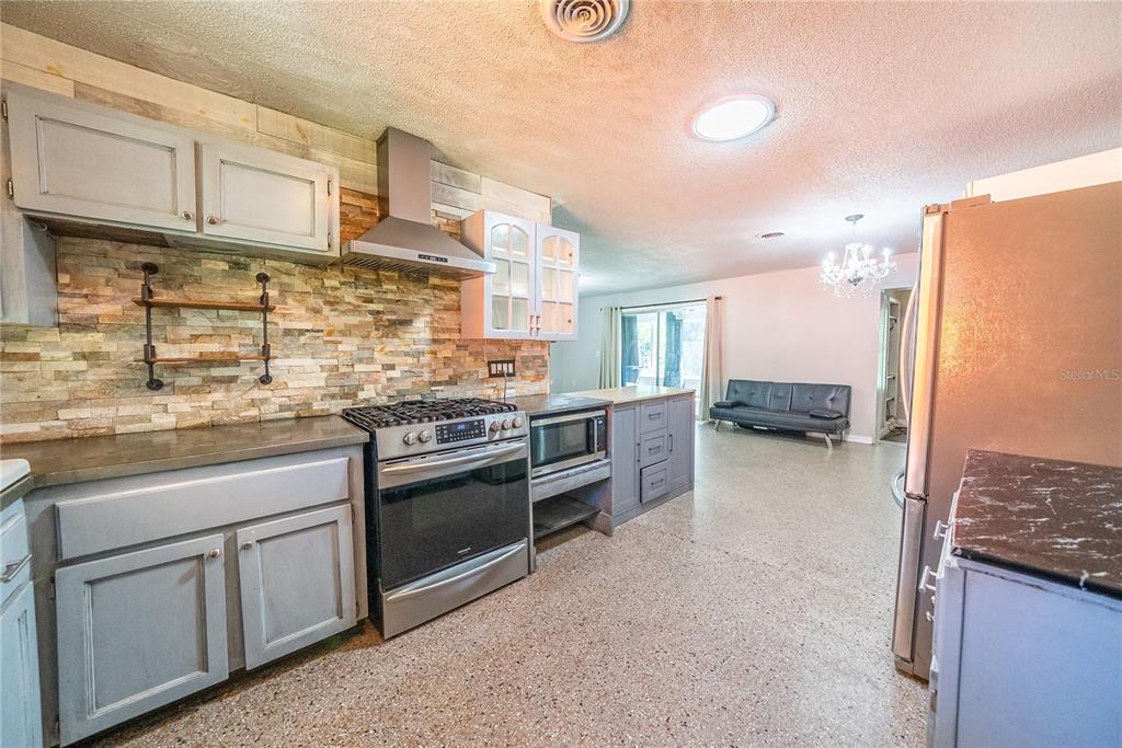 1740 Southeast 164th Circle Ocklawaha, FL 32179 - Photo 7 of 48 a kitchen with stainless steel appliances granite countertop a stove and a refrigerator
