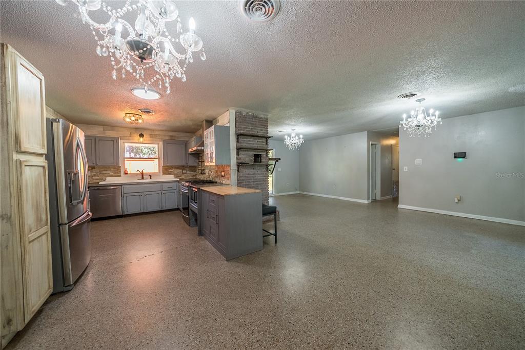 1740 Southeast 164th Circle Ocklawaha, FL 32179 - Photo 9 of 48 a kitchen with stainless steel appliances kitchen island granite countertop a refrigerator and a stove top oven
