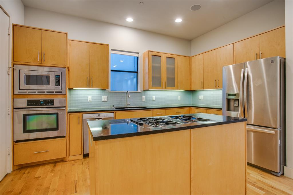 4618 Cedar Springs Road, Unit D Dallas, TX 75219 - Photo 15 of 29 a kitchen with stainless steel appliances granite countertop a refrigerator and a stove top oven