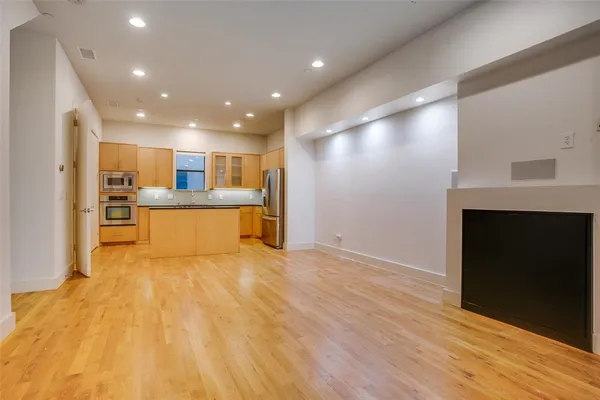 a view of an empty room with a fireplace and a window