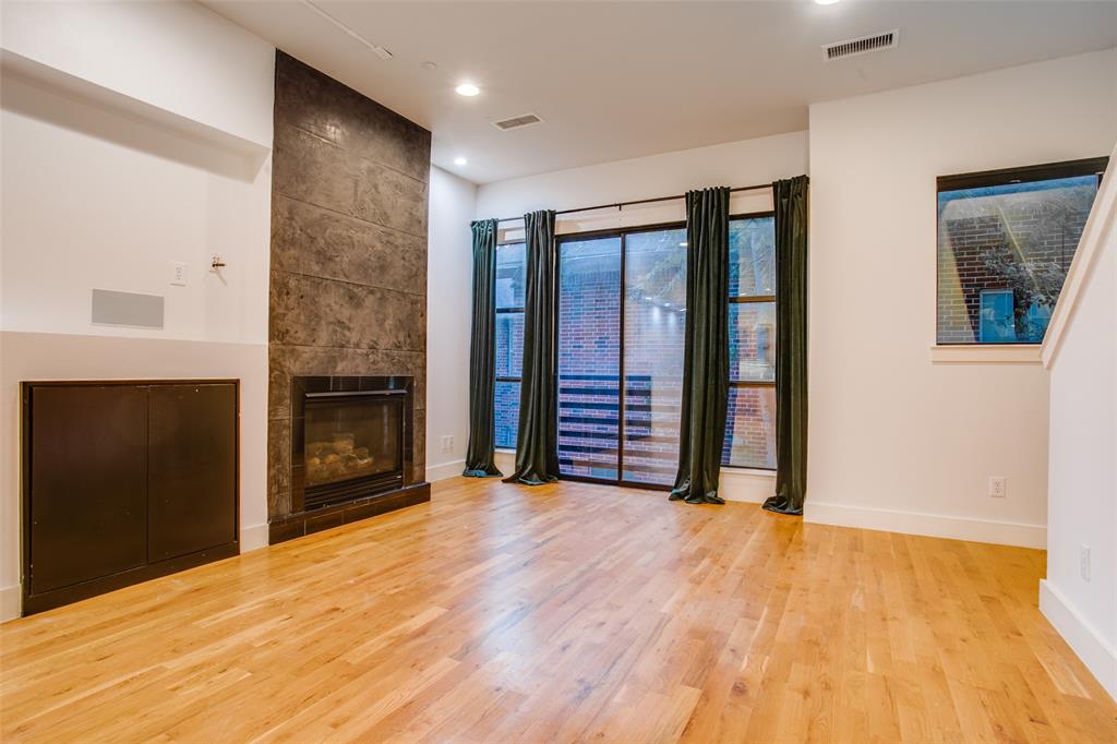 4618 Cedar Springs Road, Unit D Dallas, TX 75219 - Photo 20 of 29 a view of an empty room with a fireplace and a window