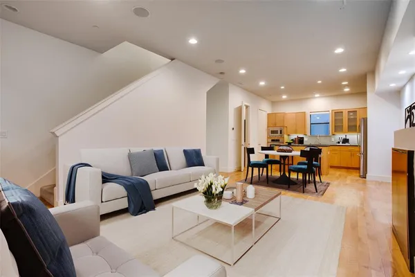 a living room with furniture and kitchen view