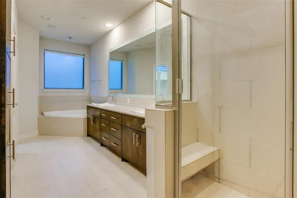 a bathroom with a tub a sink and a mirror