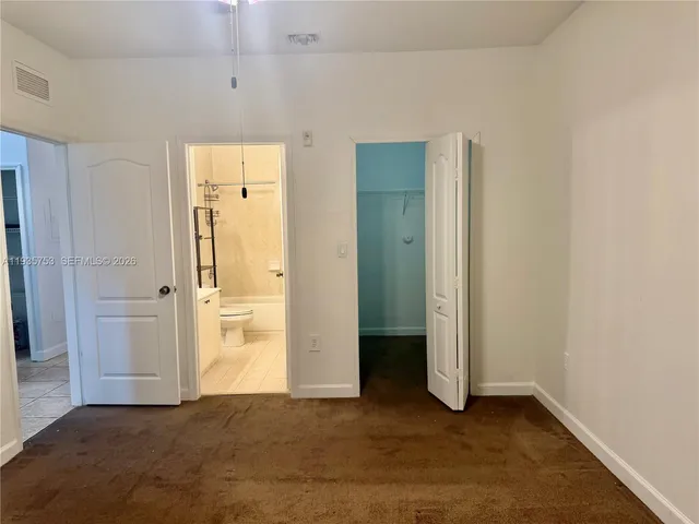an empty room with closet and a bathroom