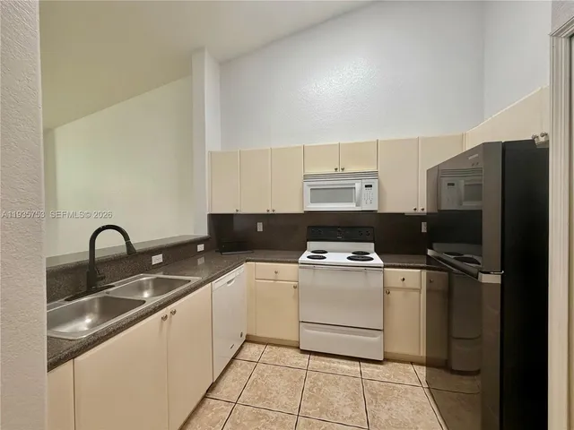 a kitchen with a sink cabinets and stainless steel appliances